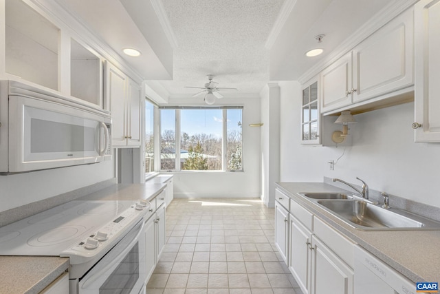 kitchen featuring crown molding, white cabinetry, a sink, a textured ceiling, and white appliances