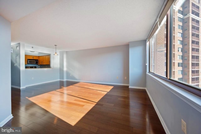 interior space featuring baseboards and dark wood-style flooring