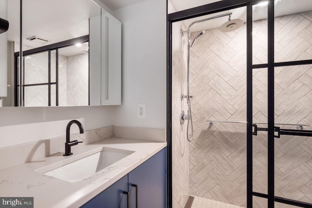 full bathroom featuring a shower stall, visible vents, and vanity