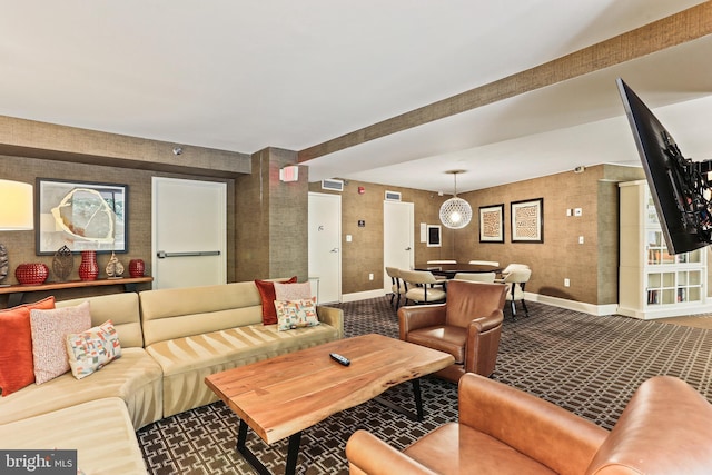 living area with wallpapered walls, visible vents, and baseboards