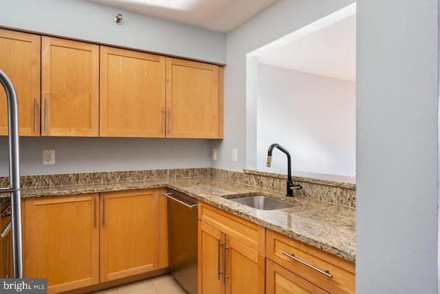 kitchen with stainless steel dishwasher, light tile patterned floors, light stone counters, and a sink