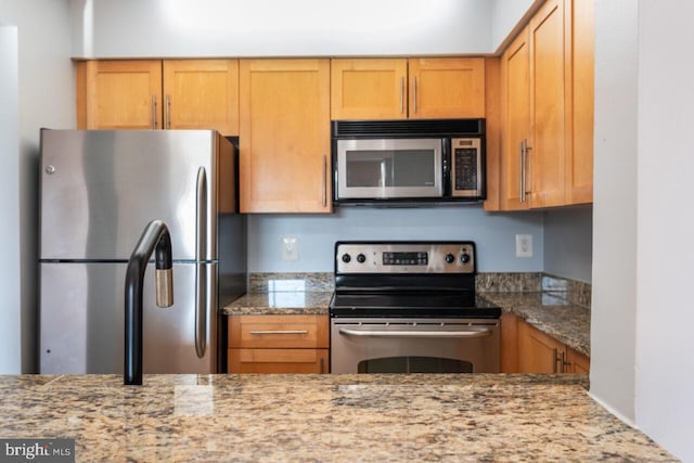 kitchen featuring stainless steel appliances and light stone countertops