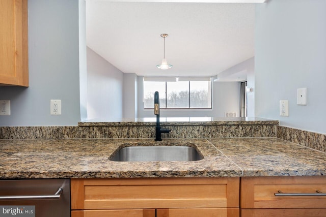 kitchen featuring dishwasher, tile counters, a sink, and decorative light fixtures