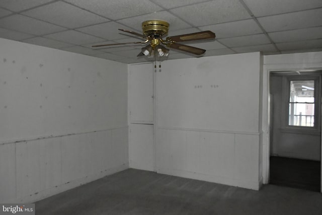 unfurnished room with a ceiling fan and a drop ceiling