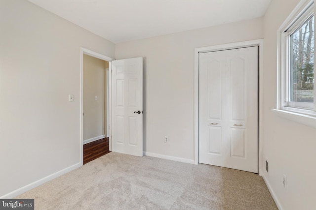 unfurnished bedroom featuring a closet, carpet flooring, and baseboards