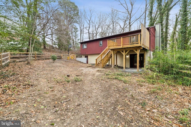 back of property with stairs, a deck, and fence