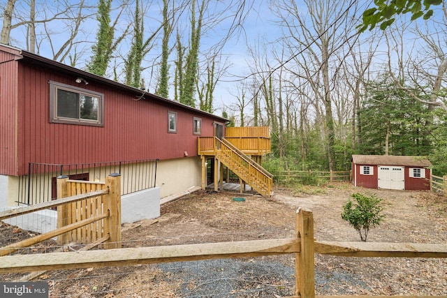 view of yard with stairway, a shed, fence, and an outdoor structure