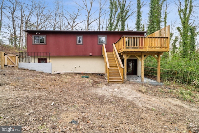 exterior space featuring stairway, fence, and a wooden deck