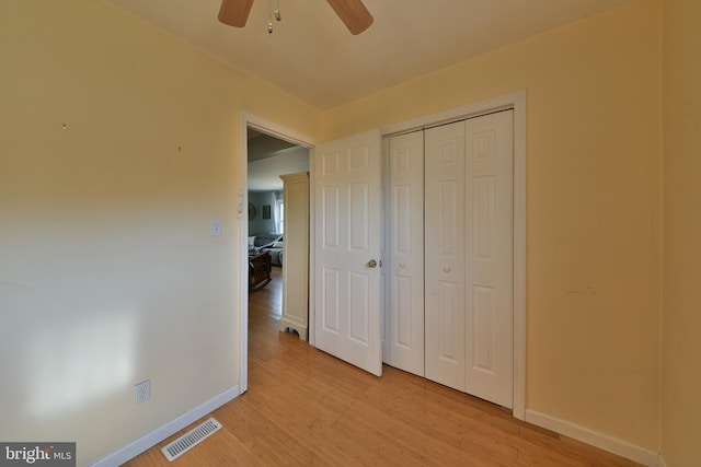 unfurnished bedroom featuring light wood-style flooring, a closet, visible vents, and baseboards