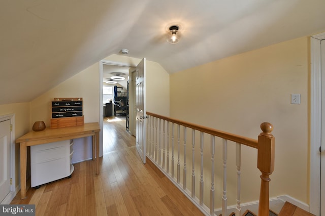 hallway featuring lofted ceiling, an upstairs landing, and hardwood / wood-style flooring