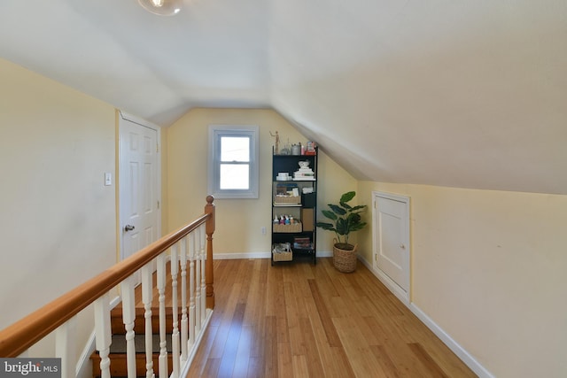 additional living space featuring lofted ceiling, light wood-style flooring, and baseboards