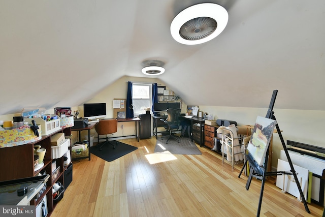 home office with vaulted ceiling and light wood-style flooring