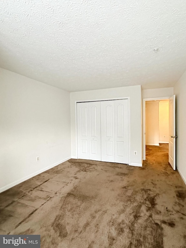 8961 Town Center Cir Unit 1-203, Upper Marlboro, MD 20774 - unfurnished bedroom with carpet, a closet, baseboards, and a textured ceiling