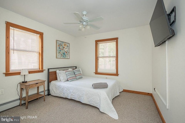 carpeted bedroom with ceiling fan, baseboards, and baseboard heating