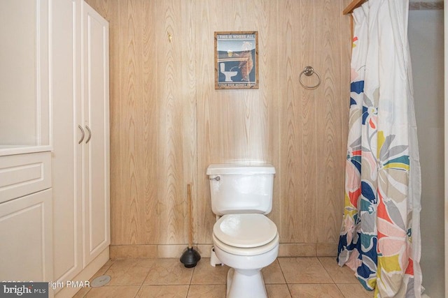 bathroom with tile patterned flooring, a shower with shower curtain, and toilet