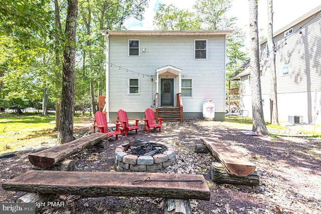 rear view of property featuring a fire pit