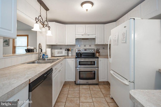 kitchen with stainless steel appliances, decorative backsplash, a sink, and under cabinet range hood