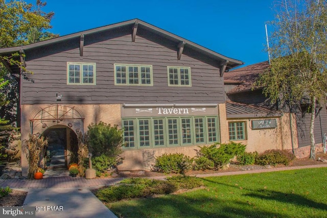 rear view of property featuring stucco siding