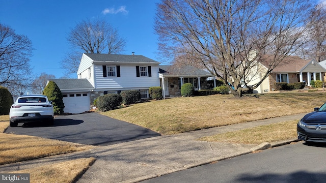 split level home with driveway, an attached garage, and a front yard