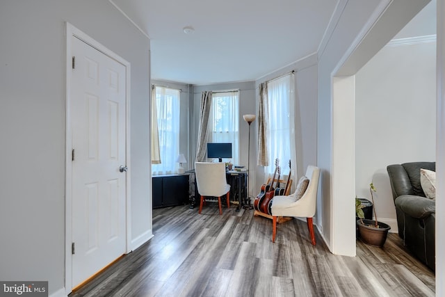 sitting room featuring ornamental molding and wood finished floors