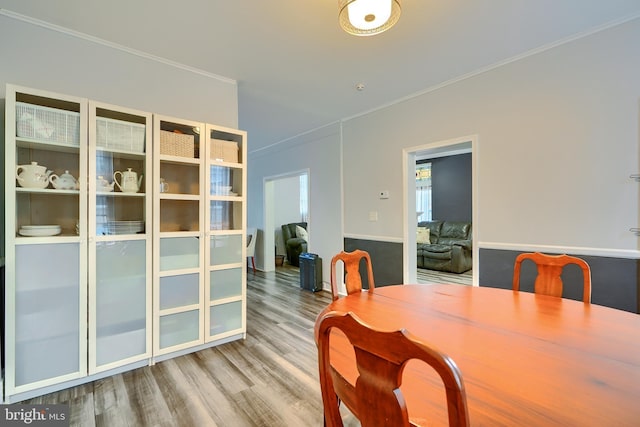 dining space with ornamental molding and wood finished floors