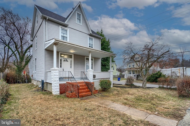 view of front of home featuring roof with shingles, a porch, a front lawn, and fence