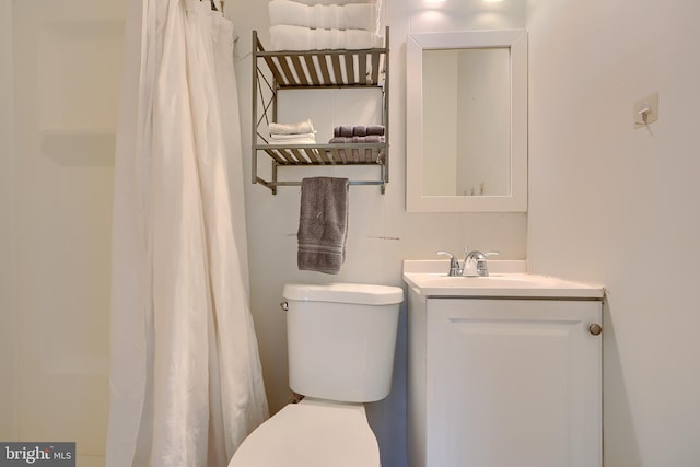 bathroom featuring a shower with curtain, vanity, and toilet