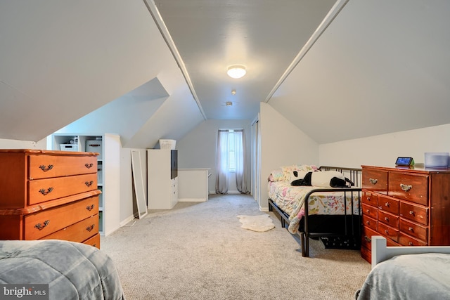 carpeted bedroom featuring baseboards and vaulted ceiling