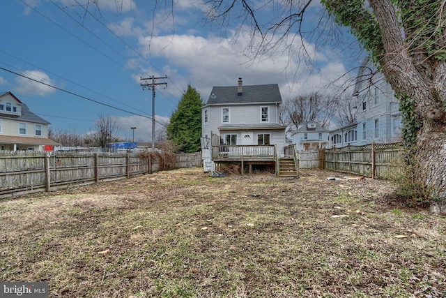 rear view of house with a fenced backyard, a chimney, and a wooden deck