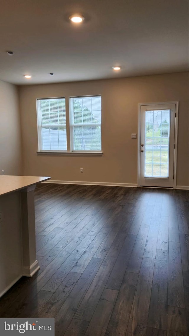 interior space with baseboards, dark wood finished floors, and recessed lighting