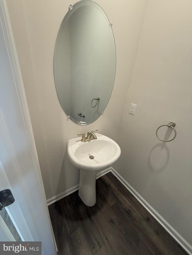 bathroom with wood finished floors and baseboards