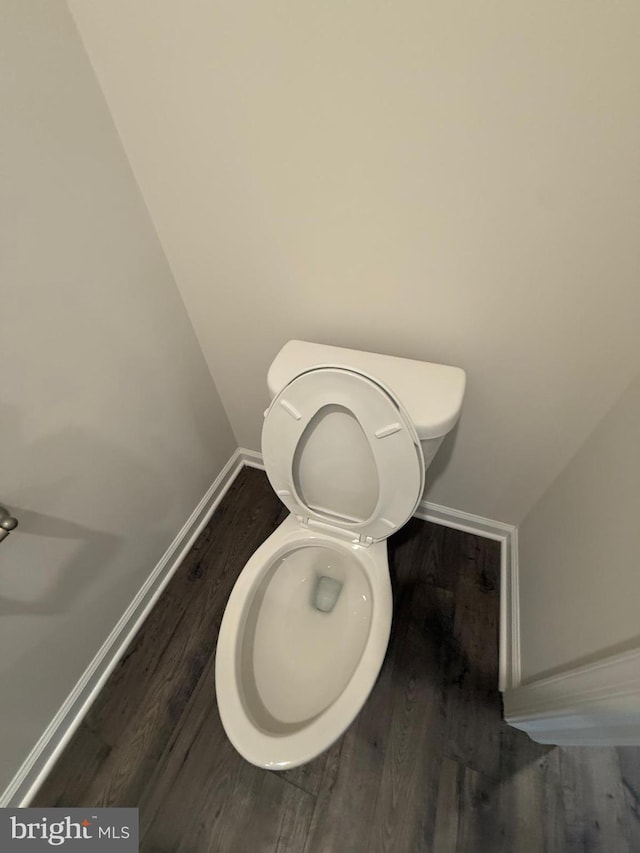 bathroom featuring toilet, baseboards, and wood finished floors