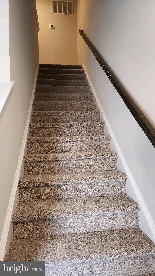 stairs featuring visible vents and baseboards