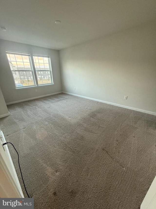 carpeted empty room with baseboards