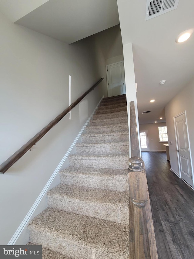 staircase featuring recessed lighting, wood finished floors, visible vents, and baseboards