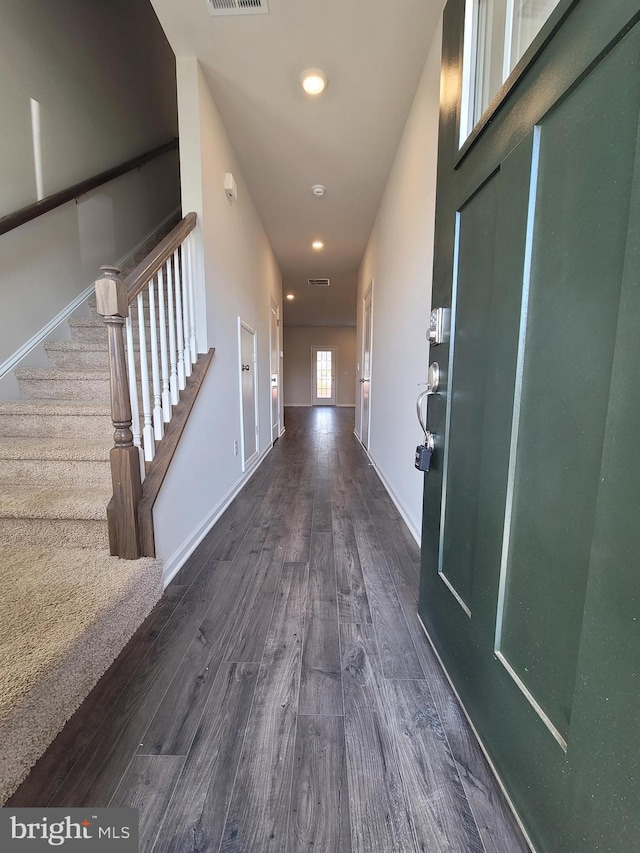 corridor with dark wood-type flooring, recessed lighting, stairway, and baseboards