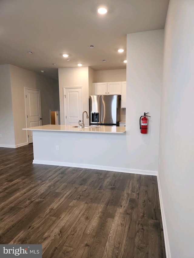 kitchen featuring white cabinets, baseboards, dark wood finished floors, and stainless steel fridge with ice dispenser