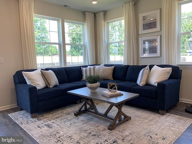 living area featuring baseboards, visible vents, and wood finished floors