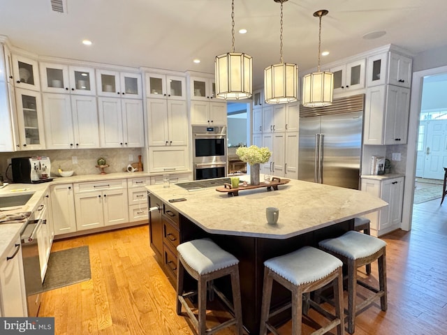 kitchen with stainless steel appliances, a kitchen island, a breakfast bar area, and tasteful backsplash