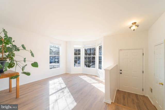 entryway featuring baseboards and light wood finished floors