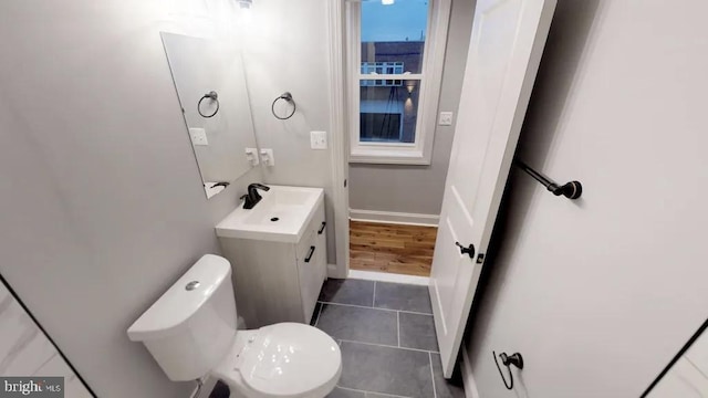 bathroom with toilet, tile patterned floors, vanity, and baseboards