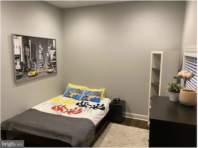 bedroom with wood finished floors and baseboards