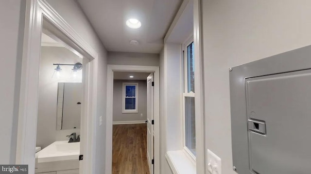 hall featuring a sink and wood finished floors