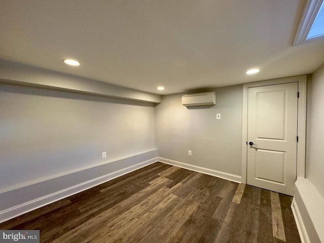 finished basement with recessed lighting, baseboards, dark wood finished floors, and a wall mounted air conditioner