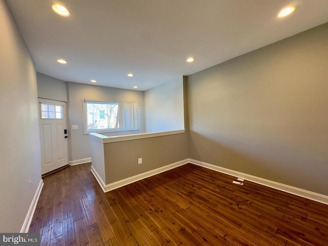 foyer entrance featuring dark wood-type flooring, recessed lighting, and baseboards