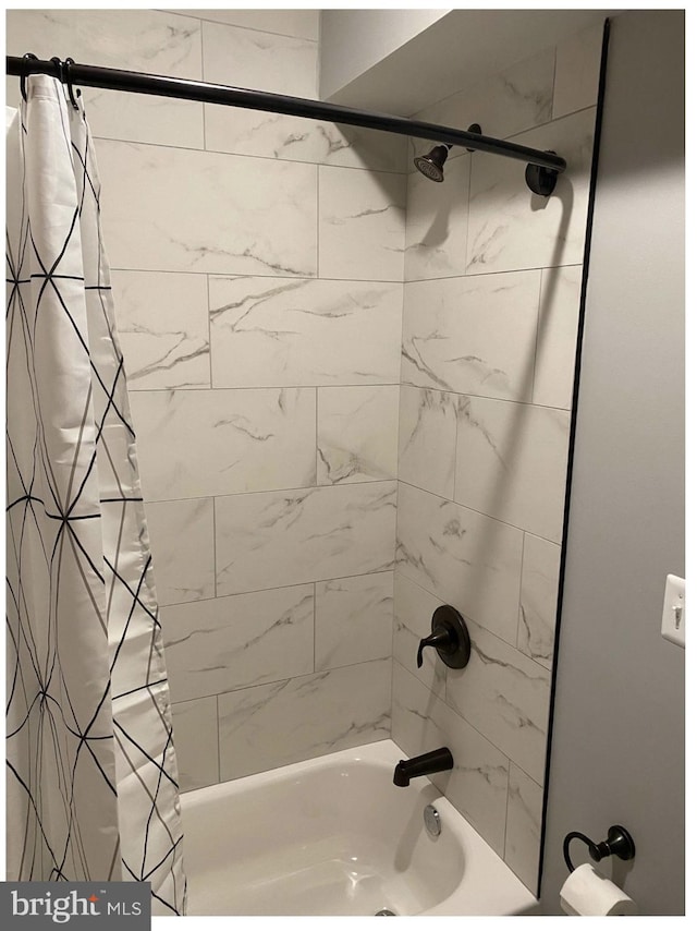 bathroom with shower / bath combo with shower curtain