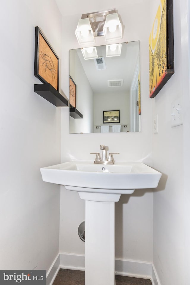 bathroom with a sink, visible vents, and baseboards