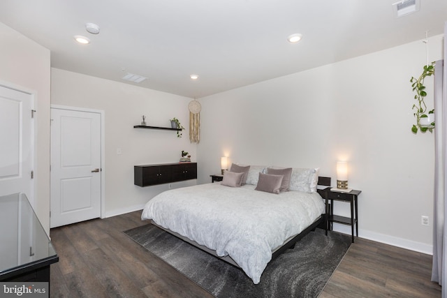 bedroom featuring visible vents, baseboards, and wood finished floors