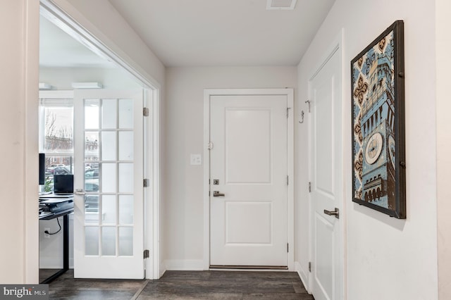 doorway to outside with dark wood-style floors, visible vents, and baseboards