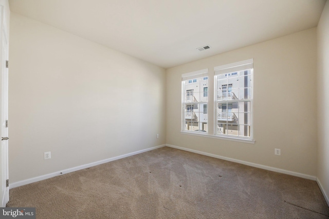 carpeted empty room featuring visible vents and baseboards